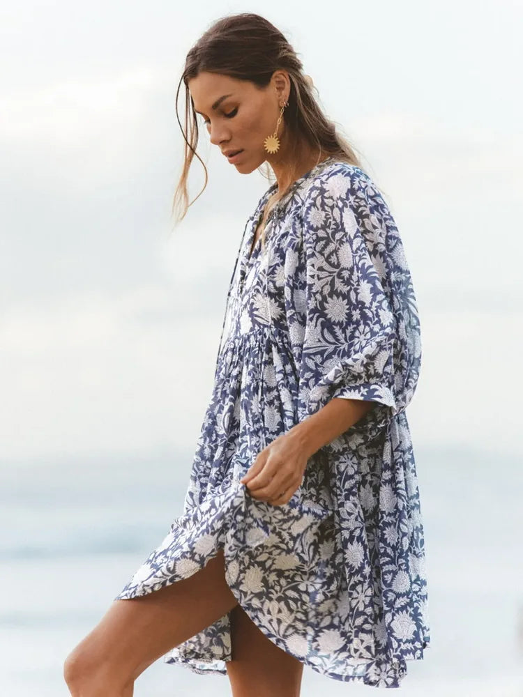 Modelo de perfil caminhando com o Vestido Oceana em movimento, valorizando o caimento leve e a estampa floral marinha


