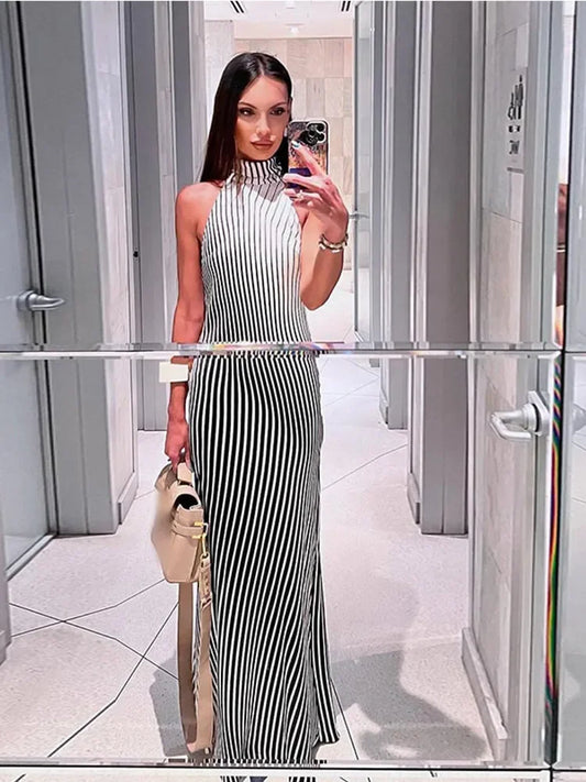 Vestido Riviera usado em look de verão com clutch clara e elegância urbana.

