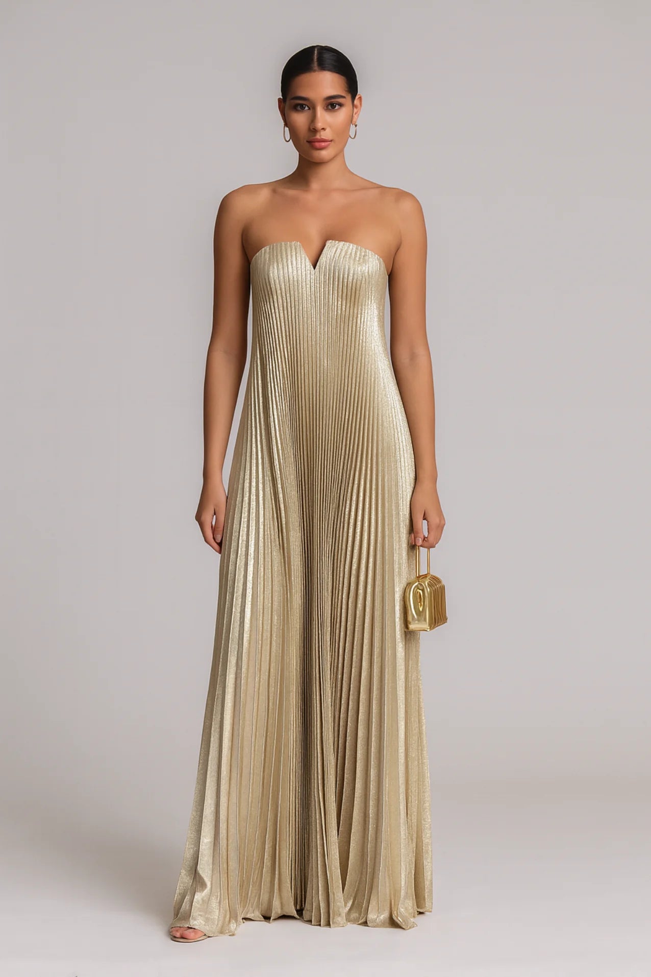 Vestido dourado plissado longo sem alças com decote em V, modelo morena clara em estúdio com clutch dourada – Dress Eleven