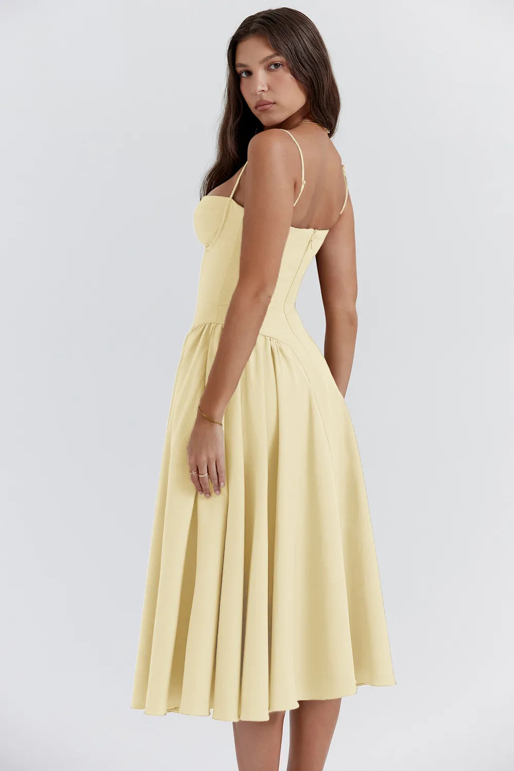 Vista lateral do Vestido Verona midi com cintura baixa, alças finas e saia rodada em comprimento meia panturrilha.