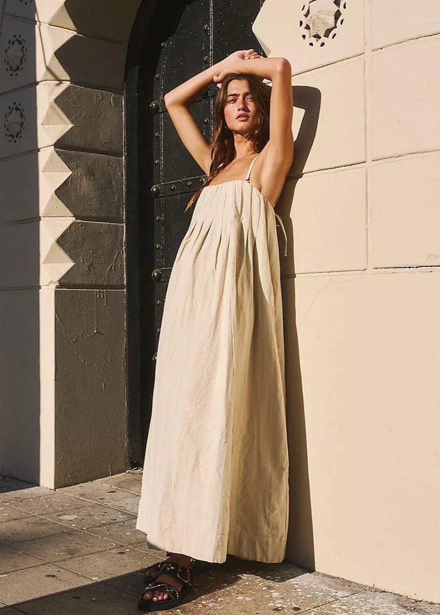 Vestido Bia em algodão bege com modelagem solta e alças finas, ideal para looks de verão com leveza e elegância