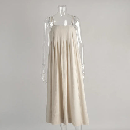 Vestido Bia em algodão bege exibido em manequim transparente, destacando a modelagem ampla e o corte reto.