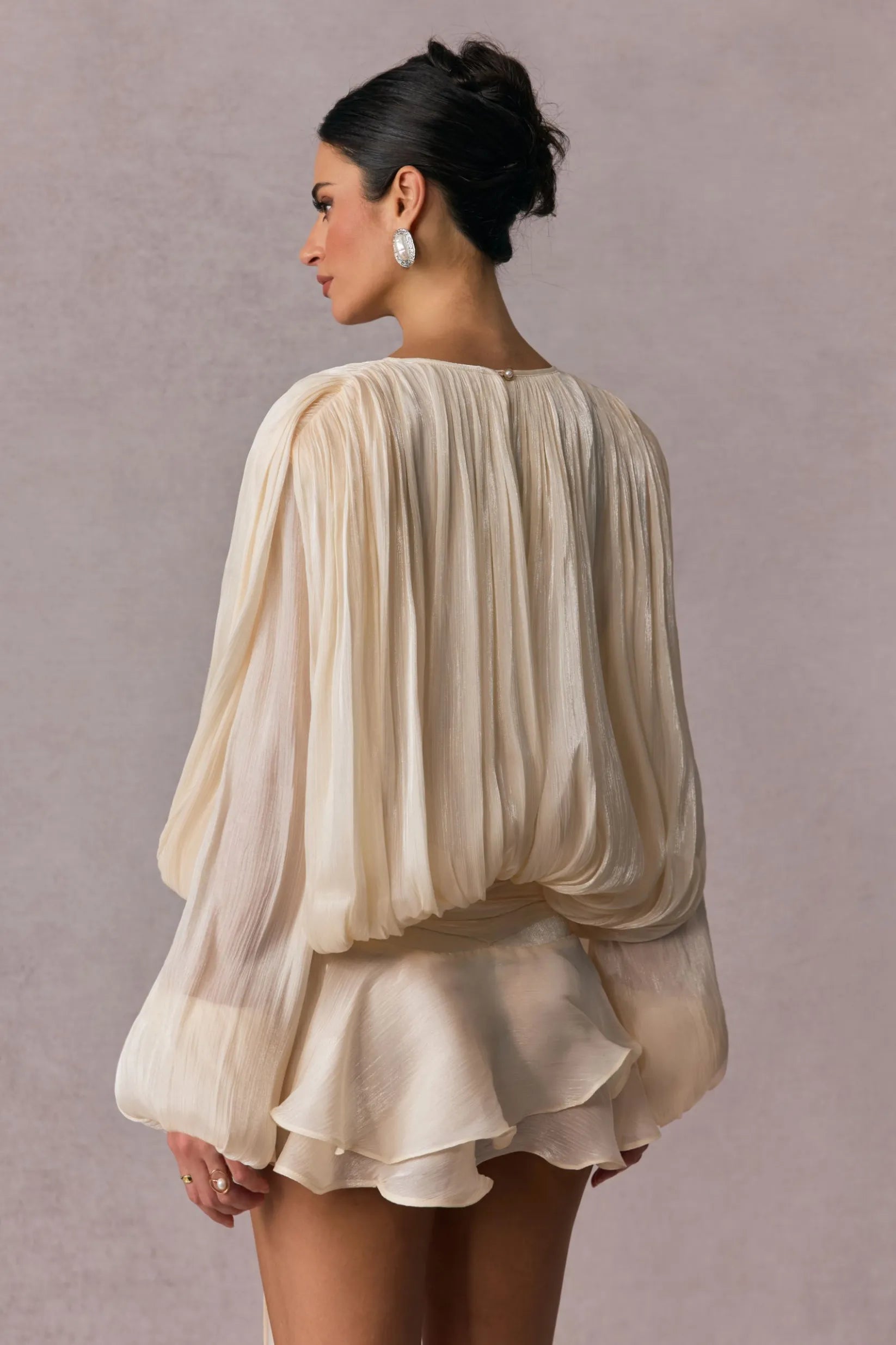 Vestido Celestine bege com mangas longas plissadas e detalhe fluido visto traseiro