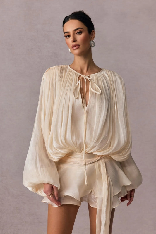 vestido Celestine bege elegante com blusa plissada manga longa e saia fluida curta