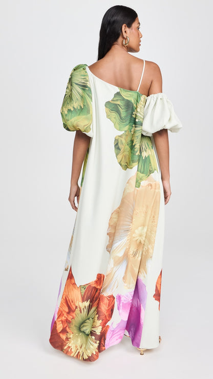 Vista traseira do vestido Hera com estampa floral, ombro único e corte fluido até o chão.