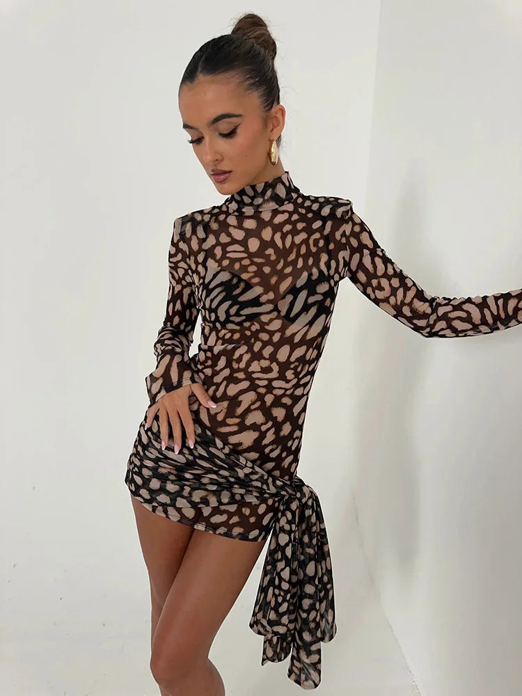 Vestido justo com estampa animal, mangas longas e detalhe lateral, modelo encostada na parede