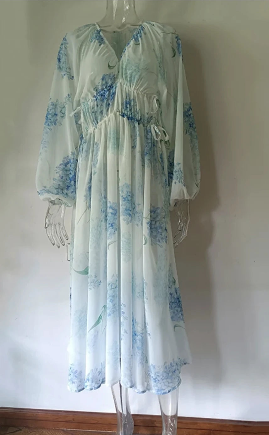 Vestido longo de chiffon floral em manequim, com elástico na cintura e caimento leve.